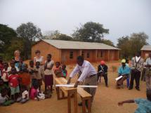 presentatie schoolbankje aan alle mensen van Chimwemwe